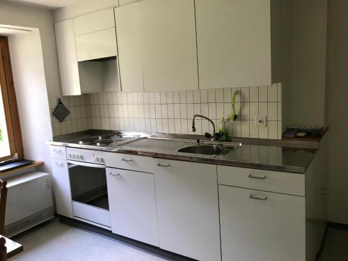 a kitchen with white cabinets and a sink at Apartment Verena in Vals