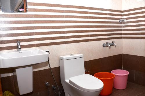 uma casa de banho com um WC branco e um lavatório. em AC MIST em Munnar