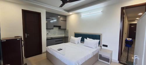 1 Schlafzimmer mit einem weißen Bett und einer Küche in der Unterkunft Hotel Leaf studio Medicity in Gurgaon