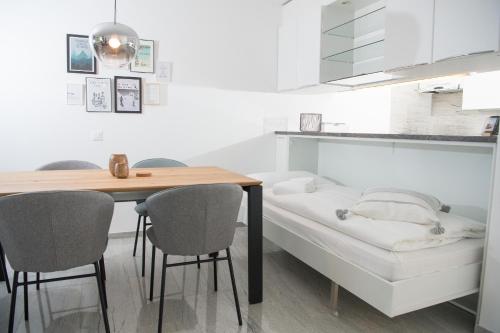eine Küche mit einem Tisch, Stühlen und einem Bett in der Unterkunft Apartment La Riva 105 Lenzerheide with an indoor Pool in Lenzerheide