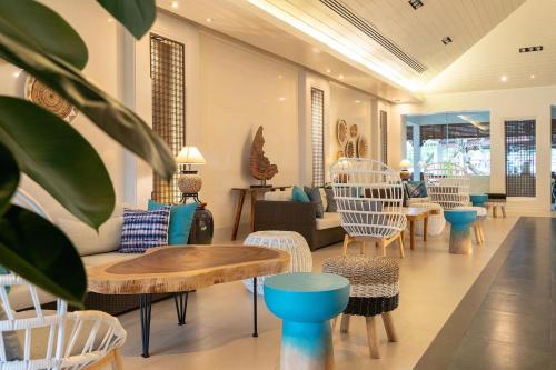 a lobby with chairs and tables and a couch at Novotel Rayong Rim Pae Resort in Klaeng