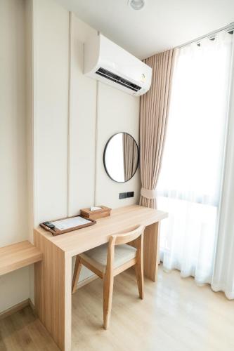 a desk in a room with a mirror and a window at Pillows boutique hotel in Chiang Mai