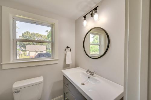 a white bathroom with a sink and a mirror at Updated Greenville Home with Backyard! in Greenville