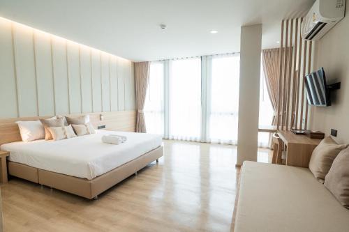 une chambre d'hôtel avec un lit et un canapé dans l'établissement Pillows boutique hotel, à Chiang Mai