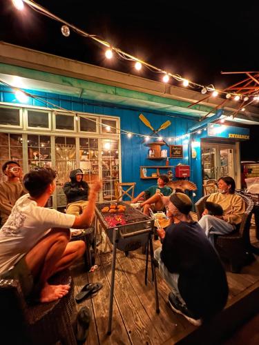 a group of people sitting around a table in a room at 秘密基地 NO's ARROW ノーズアロー in Onna