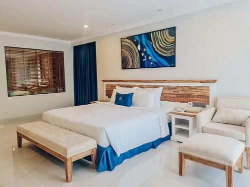 a bedroom with a large white bed and a chair at VIP Bãi Sau Villages in Vung Tau