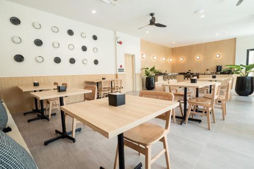 a restaurant with wooden tables and chairs and a counter at Pillows boutique hotel in Chiang Mai