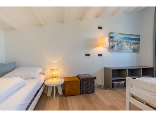 1 dormitorio con 2 camas y mesa con lámpara en Attractive holiday home, sunny garden, 150 meters from the beach, en Nieuwvliet-Bad