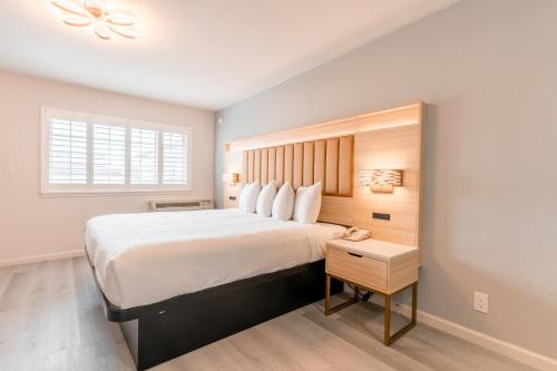 a bedroom with a large bed with a wooden headboard at Inn on Broadway in San Francisco