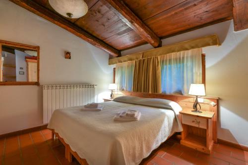 a bedroom with a bed and a table with two lamps at 28- Cantele House in Tuscany - Feste&Sagre - Relax e Sport in Castel del Piano