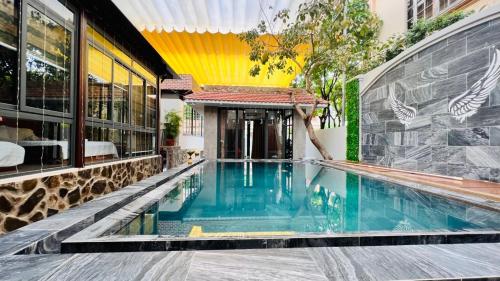 a swimming pool in front of a building at BuBu House in Vung Tau
