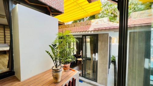 a patio with potted plants on a wooden table at BuBu House in Vung Tau
