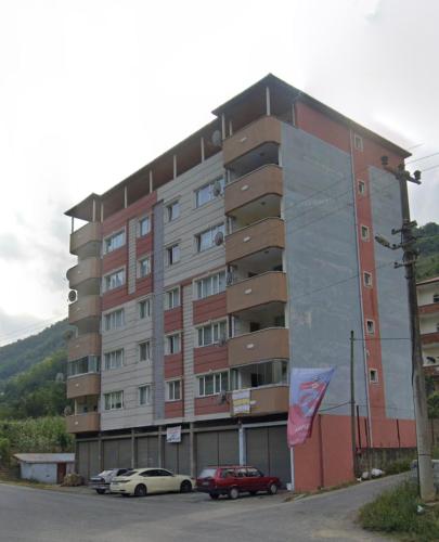 a large building with cars parked in front of it at Doğa manzaralı dere kenarında haftalık ve aylık in Macka