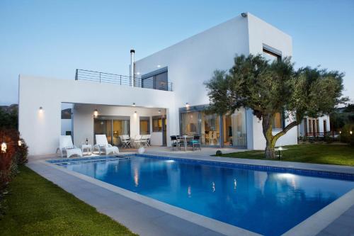 a large swimming pool in front of a house at Gramvousa Villas in Kissamos