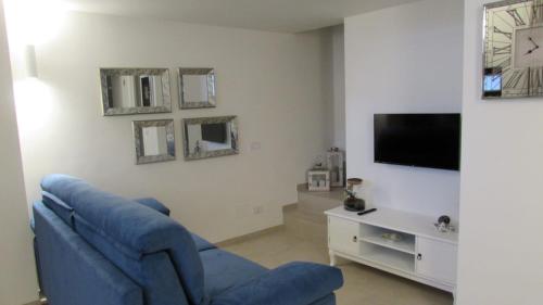 a living room with a blue couch and a tv at Palazzo Marisa in Fasano