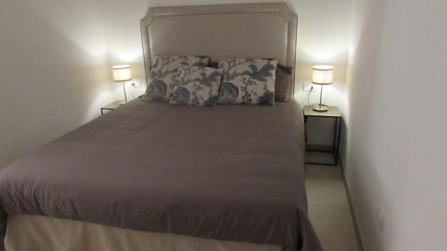 a bedroom with a bed with two lamps on two tables at Palazzo Marisa in Fasano