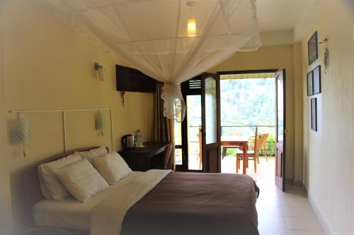Schlafzimmer mit einem Bett und einer Tür zu einer Terrasse in der Unterkunft Welcome Inn in Ella