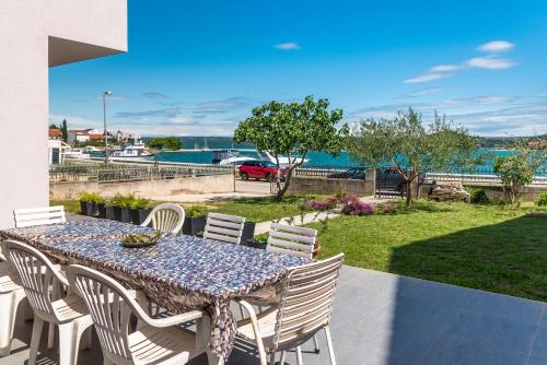 a table and chairs on a patio with a view of the water at KAIROS in Bilice