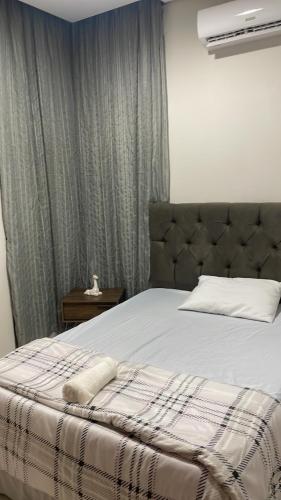 a bedroom with a bed and a window with curtains at Bela Casa Hostel in Ji-Paraná