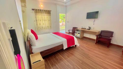 sypialnia z łóżkiem, biurkiem i telewizorem w obiekcie Caroline Resort w mieście Vung Tau