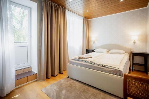a bedroom with a bed and a large window at Nautika Central Residence in Kuressaare