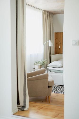 a living room with a chair and a bed at Nautika Central Residence in Kuressaare