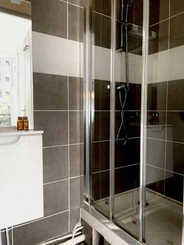 une salle de bain avec une douche avec une porte vitrée dans l'établissement Charming Bright Sunny Studio near Canal St Martin, à Paris