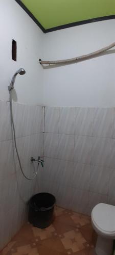 La salle de bains est pourvue d'une douche et de toilettes. dans l'établissement Zian beaugoos homestay, à Ekas