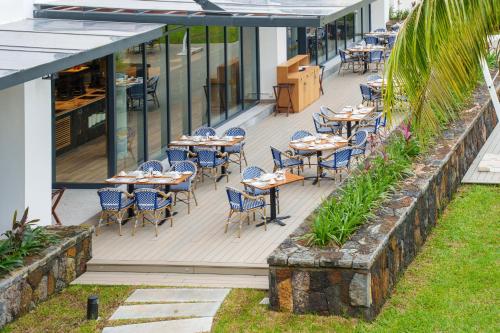 an outdoor patio with tables and chairs on a building at Ocean's Creek Beach Hotel in Balaclava