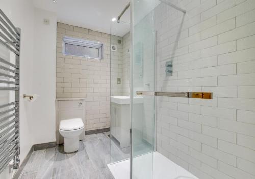 a bathroom with a toilet and a glass shower at Sandpipers in Rottingdean