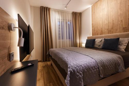 a bedroom with a bed and a desk and a window at River Breeze House in Sremska Kamenica