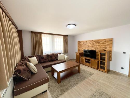 a living room with a couch and a tv at Apartments & Rooms Brijest in Plav