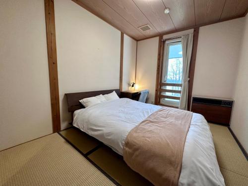 a bedroom with a large bed and a window at Lakeside Hotels Kuore in Kitashiobara