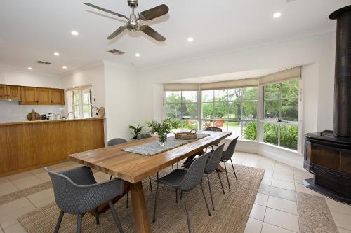 a kitchen and dining room with a wooden table and chairs at Seppeltsfield Vineyard Retreat - 3 Bedroom Holiday Home in Seppeltsfield