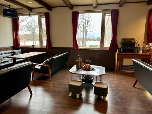 a dining room with tables and chairs and windows at Lakeside Hotels Kuore in Kitashiobara