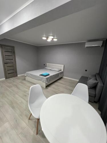 巴爾喀什的住宿－Однокомнатная квартира，配有一张床和一张桌子及椅子的房间