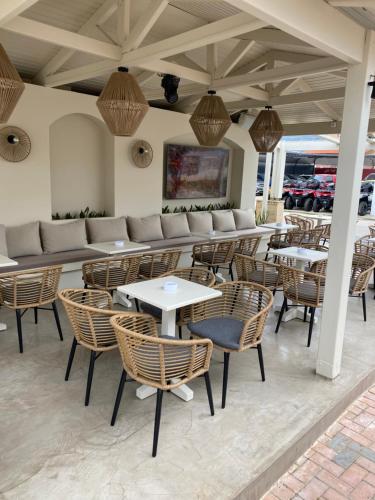 a patio with tables and chairs and a couch at Mila Malia Studios Hotel in Malia