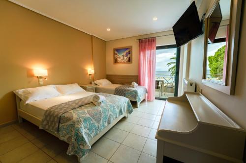 um quarto de hotel com duas camas e uma varanda em Nefeli Studios em Erateini