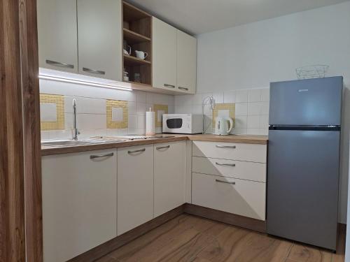 a kitchen with white cabinets and a refrigerator at Apartments Pr'Krštano in Kranjska Gora