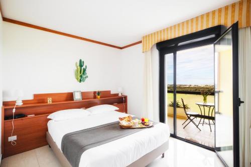 - une chambre avec un lit et une porte coulissante en verre dans l'établissement Hotel Residence Federiciano, à Valenzano