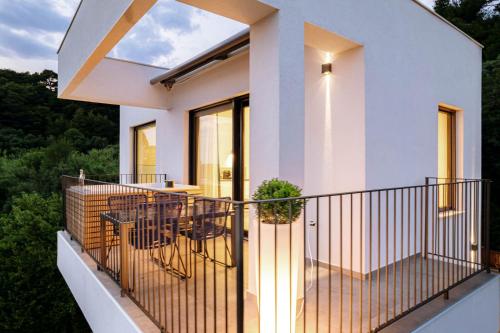 a house with a balcony with a table and chairs at Panorama Suite Dora with Jacuzzi in Palit