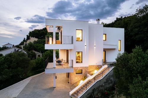 a white house on a hill with trees at Panorama Suite Dora with Jacuzzi in Palit