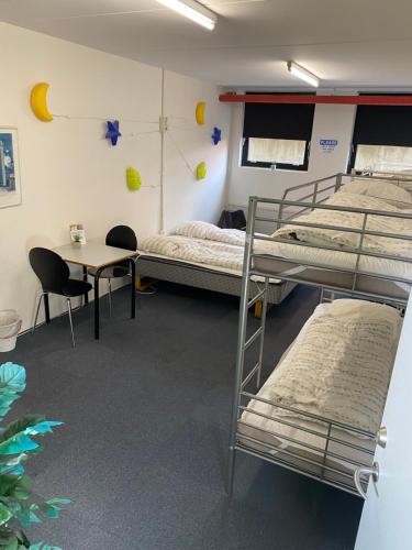 a room with three bunk beds and a table at Family rooms in the center in Grindsted