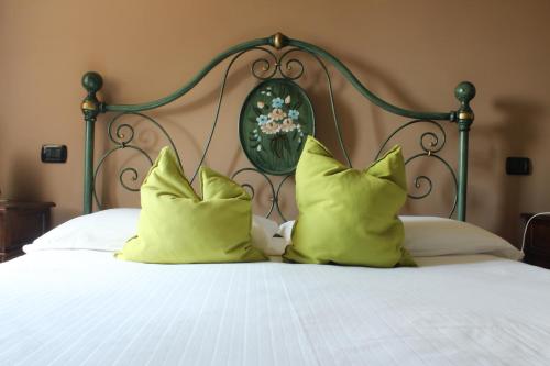 a bed with two green pillows on it at Masseria Monte Pizzi in Carovilli