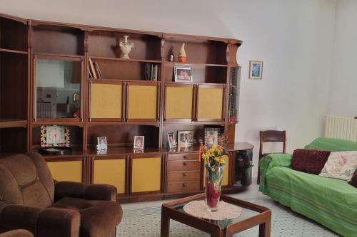 sala de estar con sofá verde y mesa en Appartement idéal pour découvrir le Sud d'Italie, en Nova Siri Marina