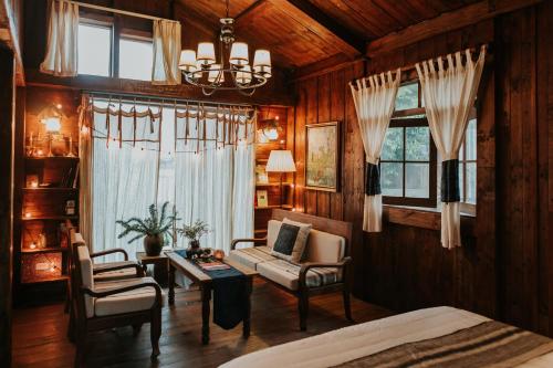 1 dormitorio con cama, sofá y mesa en Cloud Forest Tà Xùa, en Bắc Yên