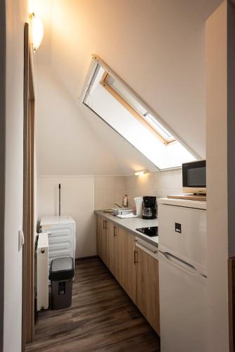 a small kitchen with a sink and a stove at Kikötő Apartmanok in Balatonboglár