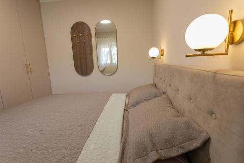 a room with a bed and two mirrors on the wall at Country Homes Dujeva in Rijeka Crnojevića
