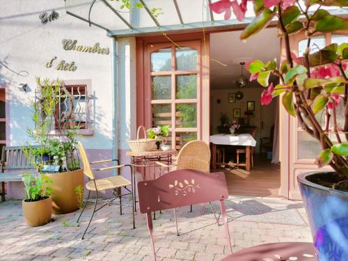 un patio con sillas, una mesa y algunas plantas en Les capucines la souris des champs, en Étival-Clairefontaine