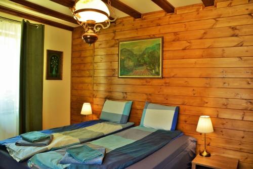 a bedroom with a wooden wall with a bed at Къща край реката/ House by the river in Vetrintsi